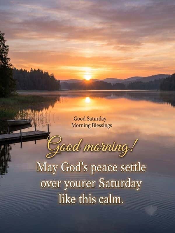 Sunrise over a serene, still lake with glowing reflection, wooden dock, and boat, featuring the text "Good Saturday Morning Blessings" and "Good morning! May God's peace settle over your Saturday like this calm."